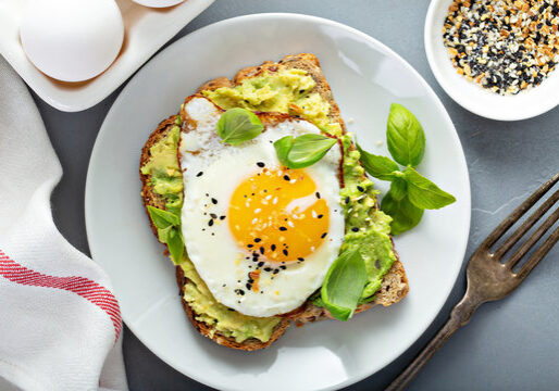 Healthy avocado toast with a fried egg and mustard on whole grain bread. Perfect for a nutritious br.