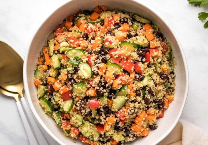 Colorful quinoa and black bean salad with fresh vegetables and herbs.