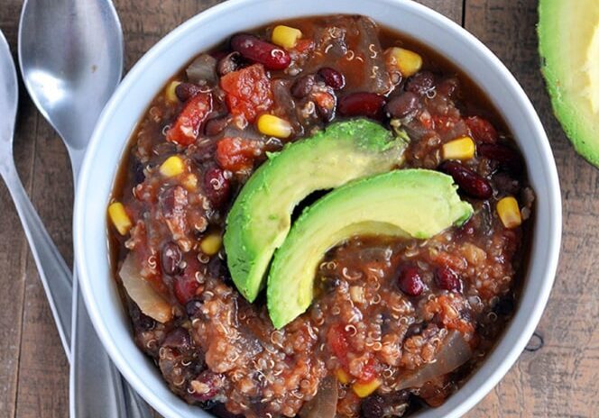 Vegan Sweet Potato and Quinoa Chili with avocado slices on top.