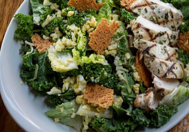 Fresh green goddess salad with grilled chicken and crunchy croutons.
