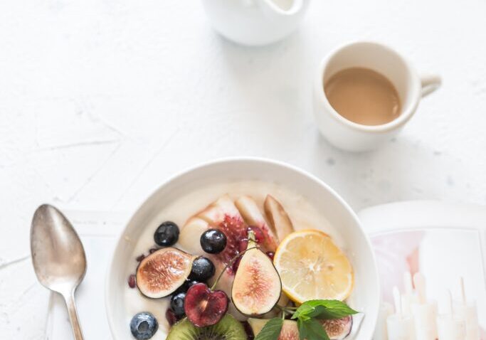 Fresh fruit bowl with kiwi, berries, and figs promoting gut health and hormone regulation.