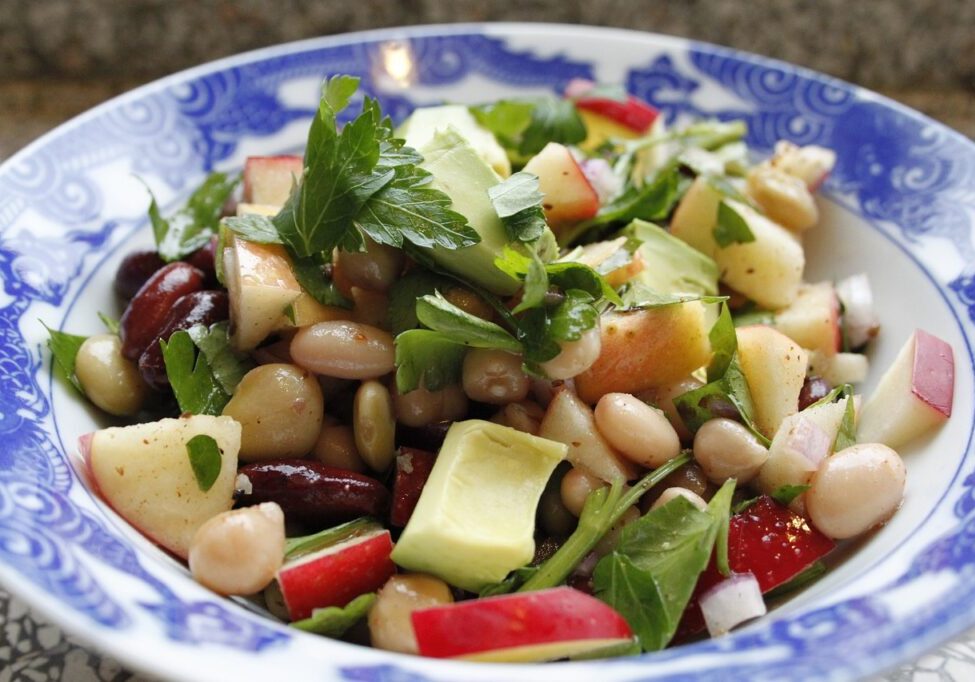 Healthy three bean salad with kidney beans, chickpeas, and black beans, mixed with fresh vegetables.