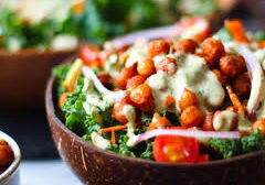 Fresh buffalo chickpea salad with greens, tomatoes, and cheese in a bowl.