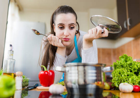 Woman worried about unhealthy cooking habits in the kitchen.