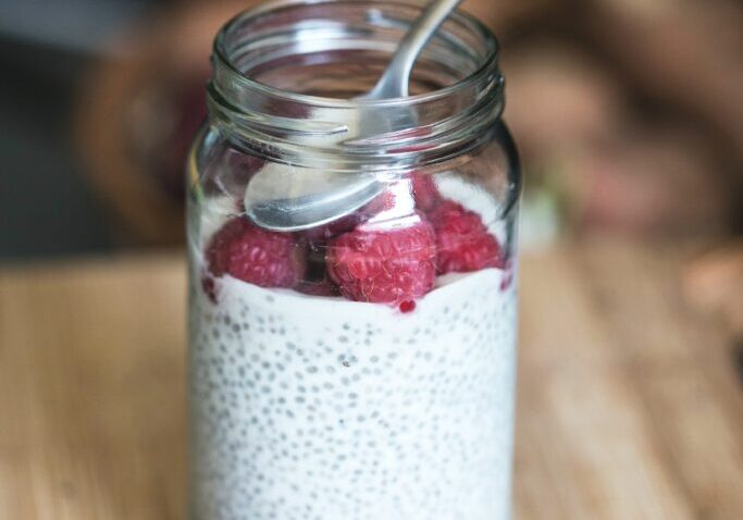 Delicious chia pudding with fresh raspberries in a glass jar.