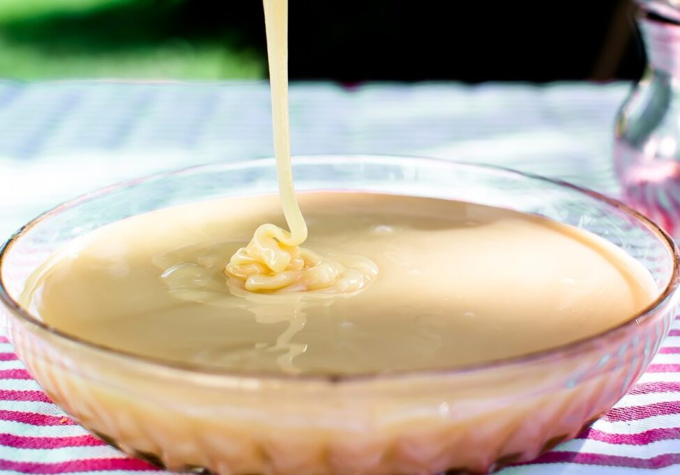 Close-up of pouring sugar-free sweetened condensed milk into a glass bowl.