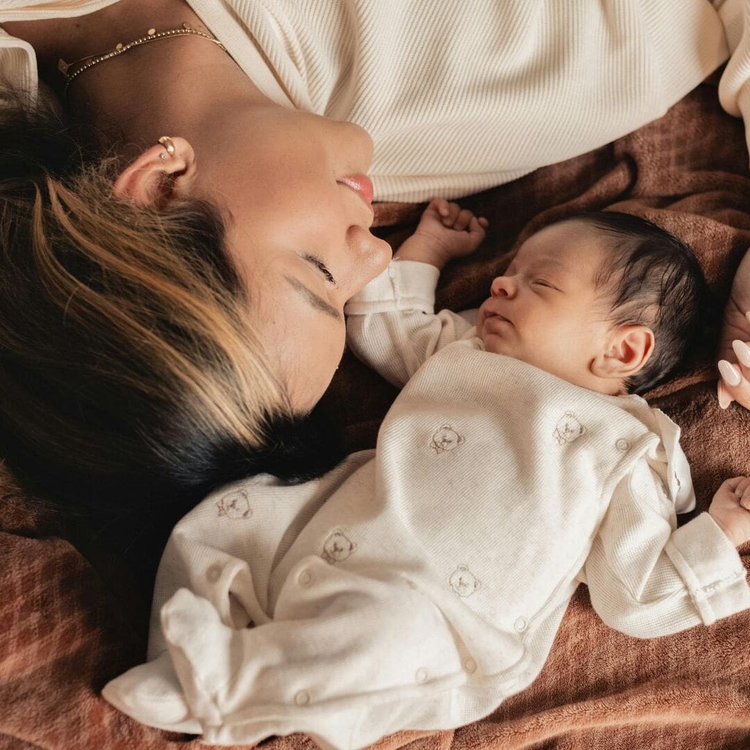 mother and baby lying on soft brown blanket. first 1000 days of baby's gut health.