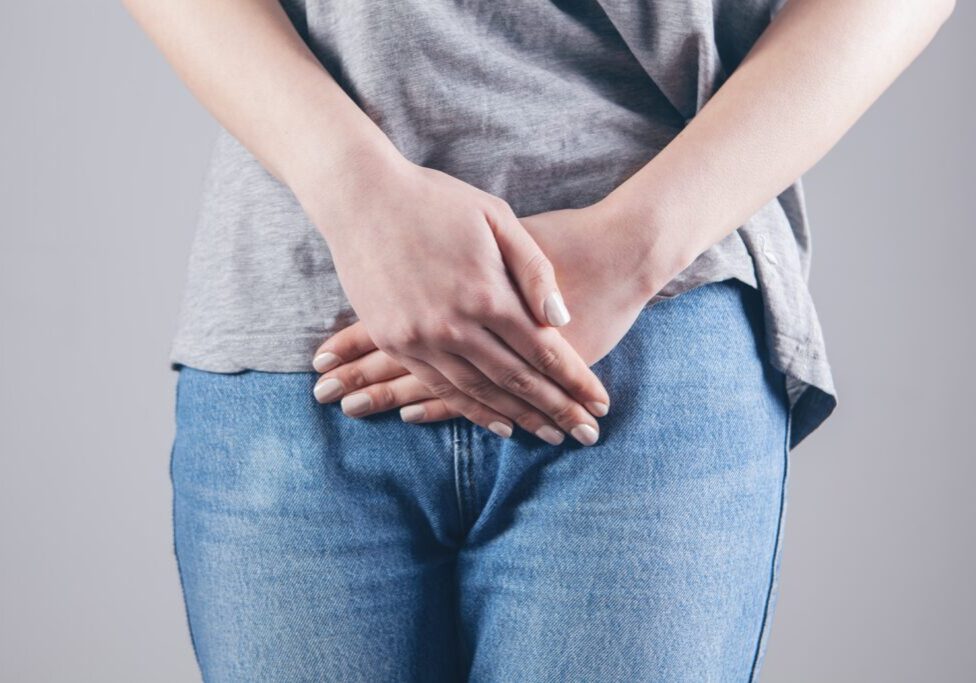 Person holding stomach indicating digestive discomfort or bloating.