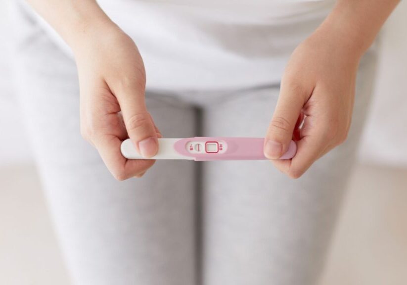 woman holding pregnancy test